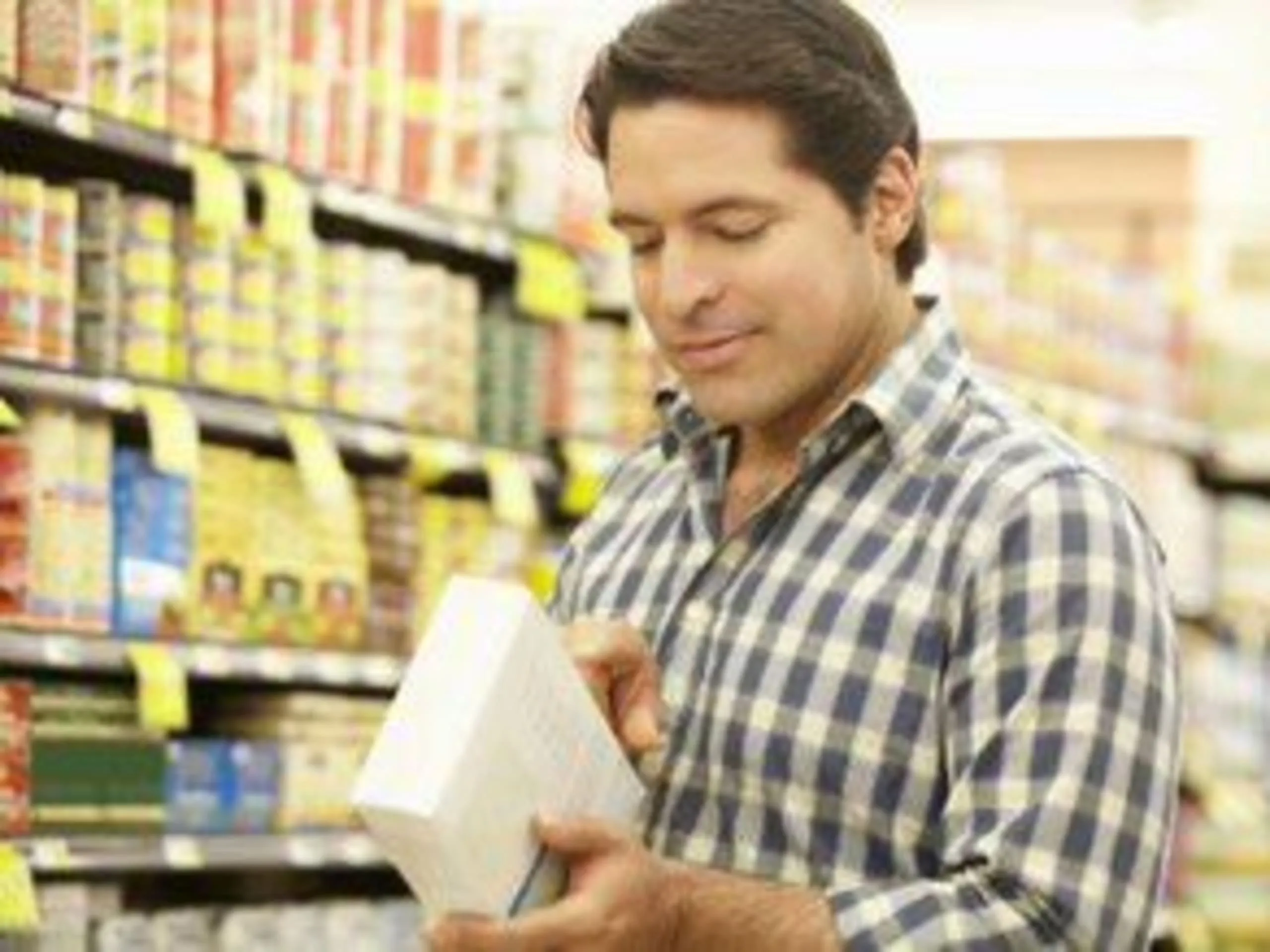 Man reading the ingredients on the product package in a grocery store